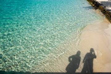 shadow of the couple on the beautiful beach and sea at the Maldives
