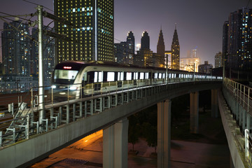 Fototapeta na wymiar At night, the light rail train shuttles through the city.
