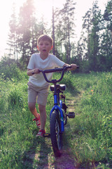 Naklejka premium seven-year-old boy riding a bike in the Park