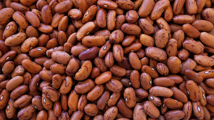Food background with dry pinto beans, a nutrient-dense legume with extensive health benefits, popular as a source of plant based protein, dietary estrogen, folates, vitamins and minerals