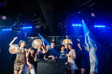 Group of eight emotional sexy women dancing and flirting with the dj in a night club. Candid picture. Holidays, celebration, nightlife and people concept.