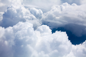 Naklejka na ściany i meble White clouds on blue sky background close up, cumulus clouds high in azure skies, beautiful aerial cloudscape view from above, sunny heaven landscape, bright cloudy sky view from airplane, copy space
