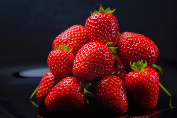 Strawberry closeup. Macro image of fresh strawberries on dark background