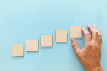 Hand arranging wood block stacking as chart or ladder. concept for growth and success