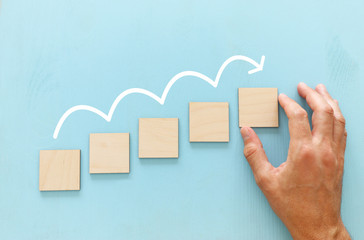 Hand arranging wood block stacking as chart or ladder. concept for growth and success