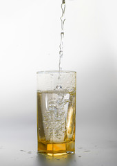 Pouring fresh drink water to yellow glass