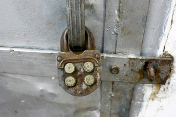 Old combination lock on metal old doors, close-up.