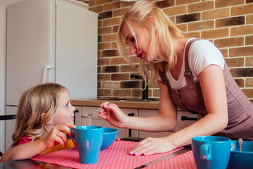 beautiful caucasian girl does not want to eating kitchen with her sister