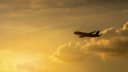 Fototapeta na wymiar The silhouette of the passenger plane at sunset