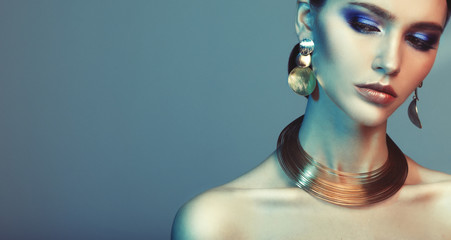 beautiful fashion model wearing elegant jewelry in color light