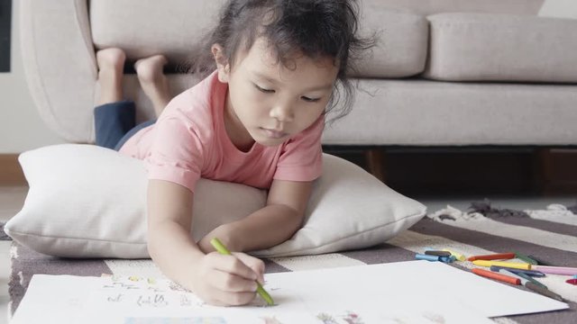 Asian girls wearing casual dresses are drawing and painting at home.
