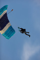 Skydiver with a parachute against the blue sky close-up. Parachute jumps.