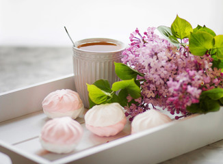 The tea served in a gift box with marshmallows and a bouquet of a lilac. Close up.