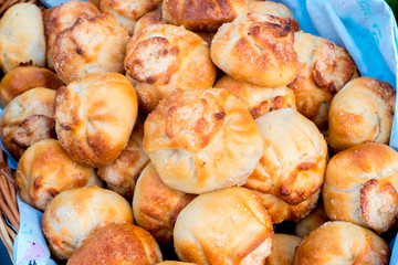 Traditional Russian baked pies pirozhki (patties) in a basket. Ruddy yeast buns with a golden crust. White background. isolated. Pies can be cooked with cabbage, apples, eggs, berries, fruit, meat