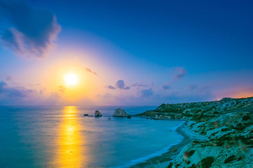 Republic of Cyprus. Aphrodite rock at sunset, vast panorama. Sunset on the Aphrodite bay shore....