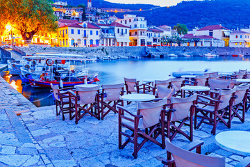 Greece, Europe - scenic twilight scenery of street cafe in ancient Greek harbor Nafpaktos. Nafpaktos was important part of ancient Greece.  Nowdays Nafpaktos is popular travel destination in Greece. - obrazy, fototapety, plakaty