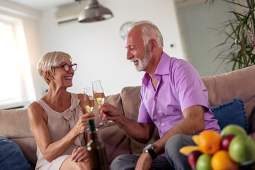 Senior couple toast in living room