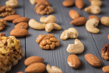 Assortment of nuts on gray wooden table. Cashew, hazelnuts, walnuts, almonds.