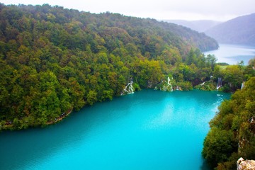 Fototapeta na wymiar Amazing breathtaking landscape in Plitvice National Park, Croatia. Lakes and waterfalls in forest. Crystal clear azure blue water. Top view of Plitvice Lakes.