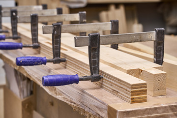 Gluing and clamping wooden detail. Production of wood furniture. Furniture manufacture. Close-up