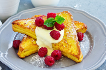 French toast with english sauce and raspberries.