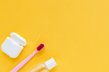 Dental hygiene - tooth brushes, dental floss, mouthwash flat lay, top view, copy space, yellow background