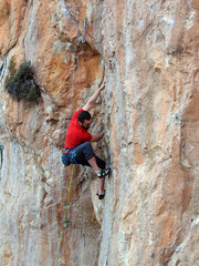 A strong man in the red t-shirt in climbing in Geyikbayiri in Turkey