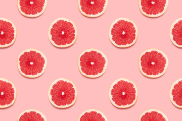 Grapefruit slices tropical seamless pattern on pink background Minimal summer concept. Flat lay, trendy juicy color.