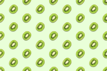 Kiwi slices seamless pattern on pastel green background. Minimal summer concept. Flat lay, trendy juicy color.