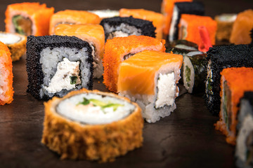 A lot of different rolls in the Japanese style on a dark surface