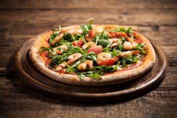 Pizza covered with roquette and shrimps