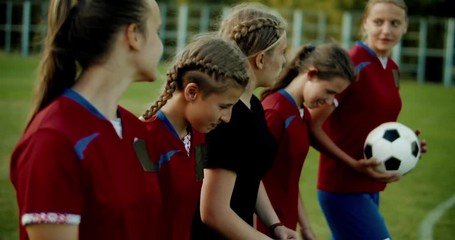 TRACKING Teenager kid girls soccer players talking and laughing after training. 4K UHD 60 FPS SLO MO