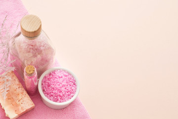 Body treatment and relaxation. Top view of pink bath salt and handmade soap bar on peach background. Copy space.