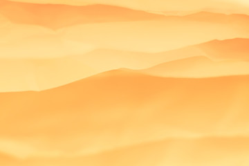 Closeup of orange paper layers stack abstract art background. Blur sandy desert hills effect. Copy space.