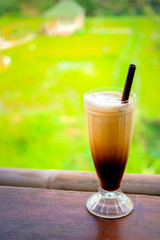 glass of homemade organic coffee with plantation background