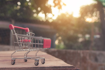 Shopping concept - Empty red shopping cart on brown wood table. online shopping consumers can shop from home and delivery service. with copy space