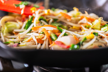 Process of cooking of sweet and crunchy stir fry with beansprouts in the wok, Macro image