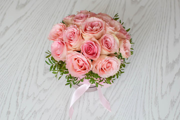 Beautiful round bouquet of pink roses on a white wooden background. Gift for holiday, birthday, Wedding, Mother's Day, Valentine's day, Women's Day. Top view. 