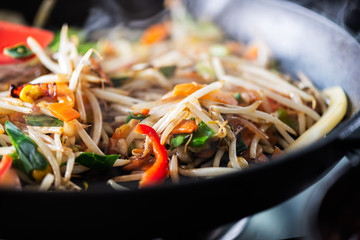 Process of cooking of sweet and crunchy stir fry with beansprouts in the wok, Macro image