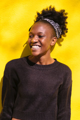 Young african woman standing and smiling at camera