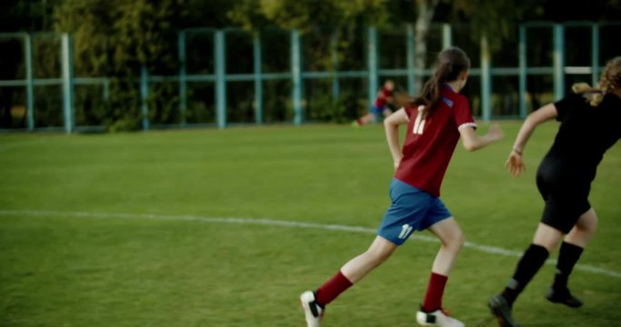 TRACKING Caucasian teenager girl soccer football team during practice. 4K UHD 60 FPS SLOW MOTION