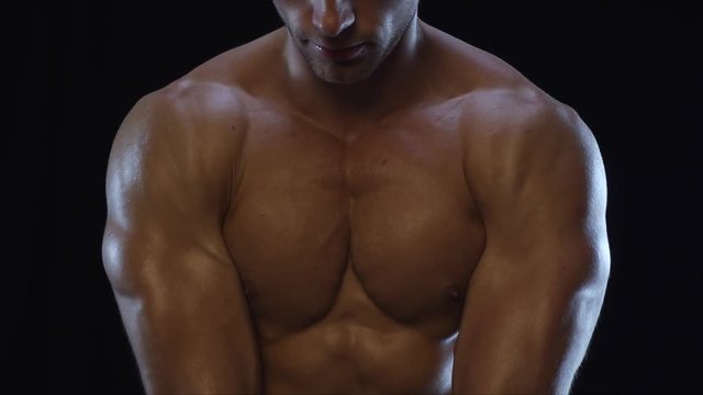 Young fit guy posing, showing shoulder muscles, slow motion