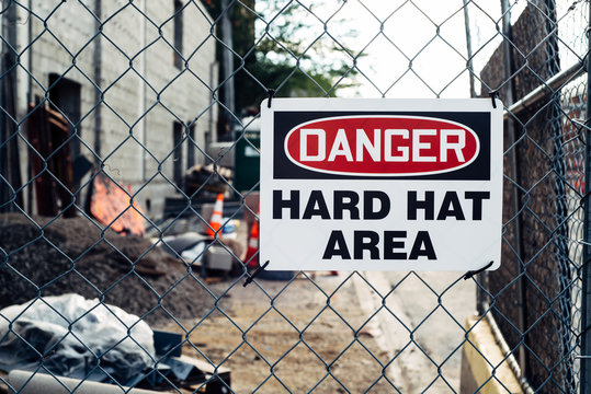 Hard Hat area warning sign on a fence at a construction site