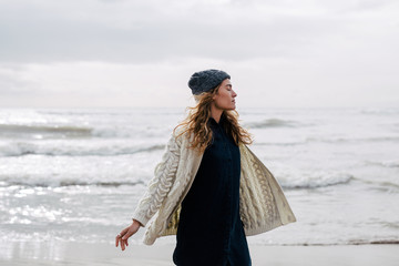 Woman enjoying on the beach in winter day.