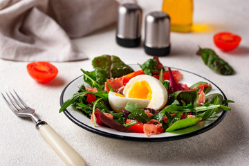 Healthy salad with prosciutto, tomato and egg
