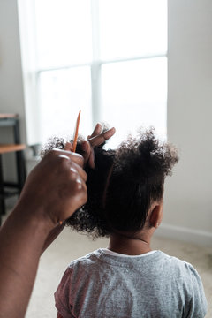 Mother doing her daughters hair