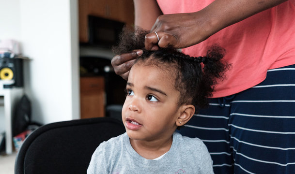 Mother doing her daughters hair
