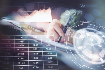 Financial forex graph displayed on hands taking notes background. Concept of research. Multi exposure