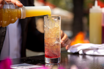 A bartender prepares a drink recipe at the bar