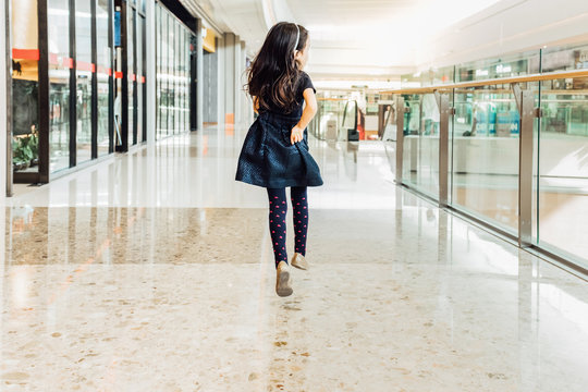 Adorable girl running at shopping center
